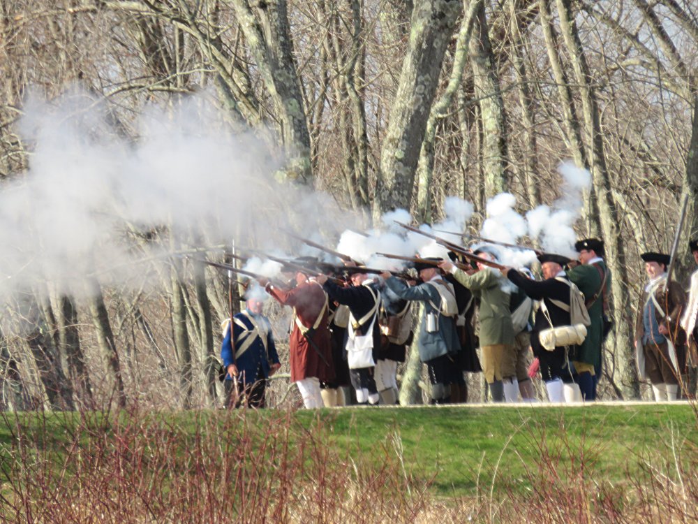 Minutemen fire a volley at the Redcoats